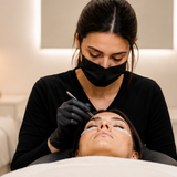 Lash artist applying extensions to a client in a softly lit luxury lash studio.