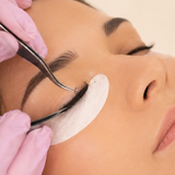 Lash artist carefully separating extensions with tweezers.