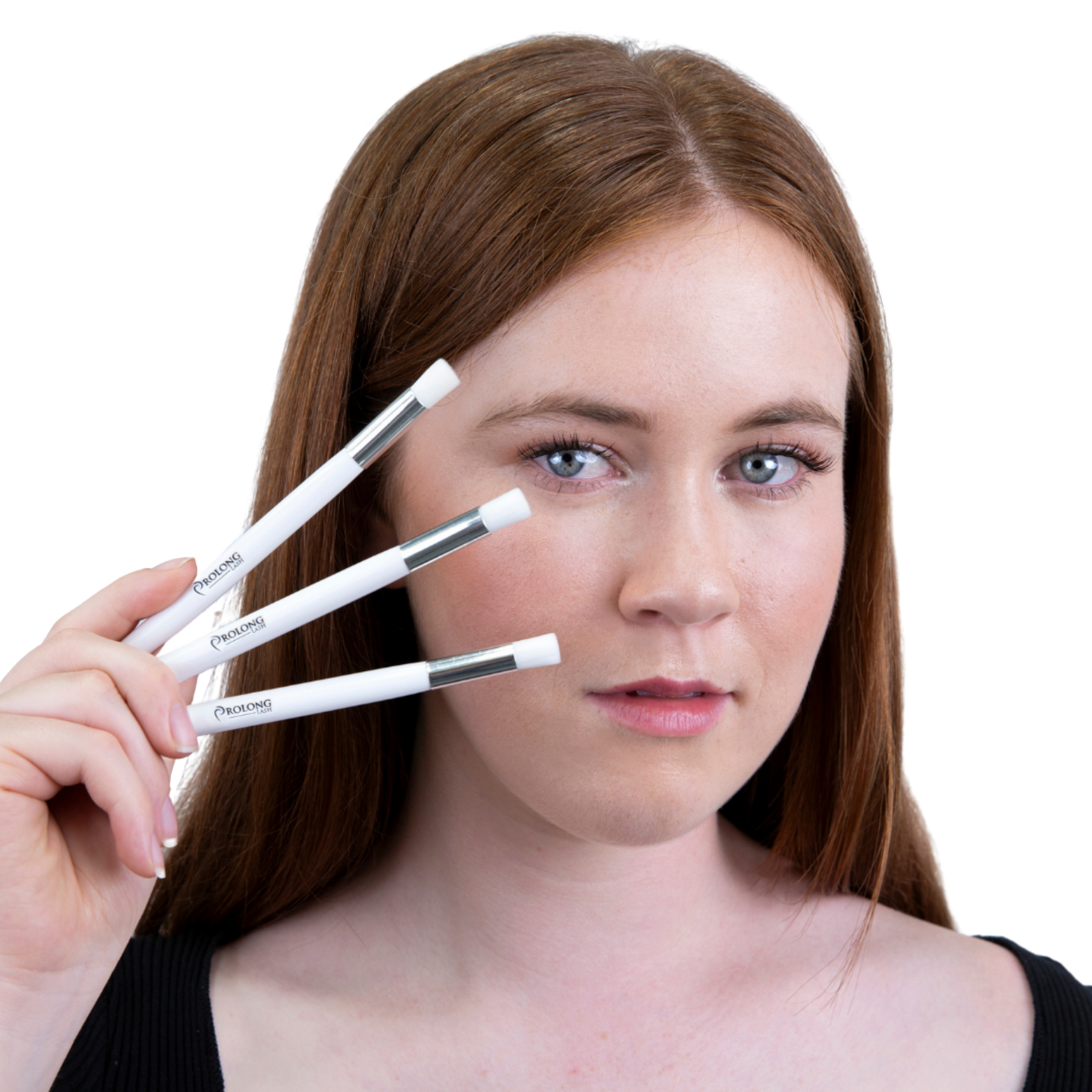 Women holding 3 eyelash extension cleansing brushes near her face